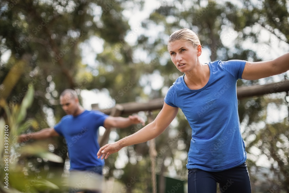 Fit man and woman during obstacle course training Fit man and woman during obstacle course training