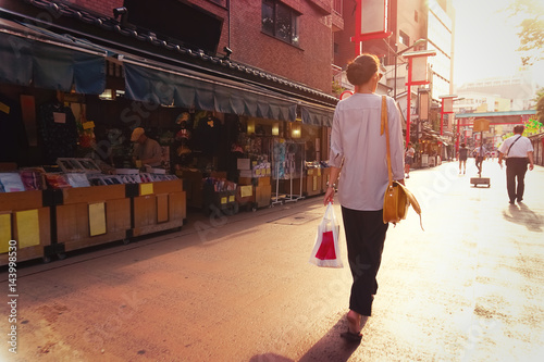 Young woman walking on the street in Asakusa Tokyo at sunset looking ahead