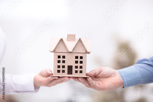 Female hand giving keys from new apartment to male hand on background