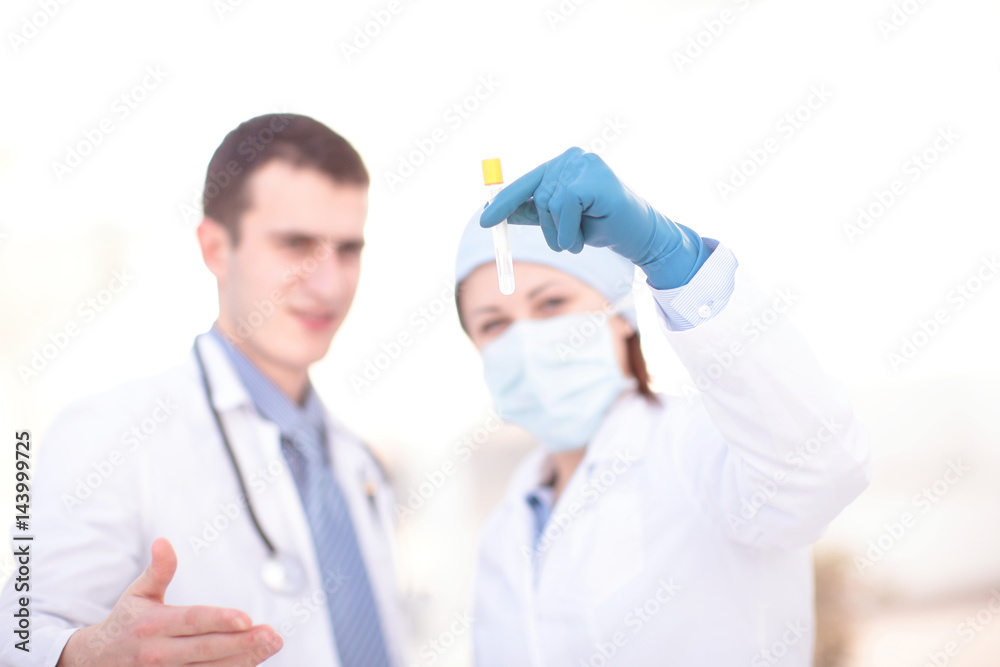 Doctors examining a blood sample in a laboratory Doctors examining a blood sample in a laboratory