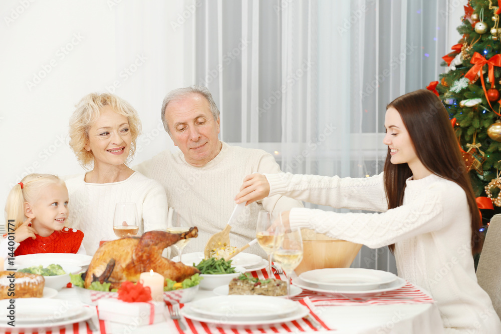 Happy family having Christmas dinner in living room Happy family having Christmas dinner in living room