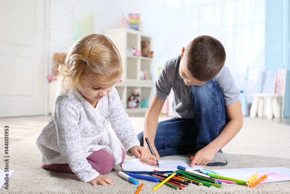 Fototapeta premium Two cute little children sitting on floor and painting