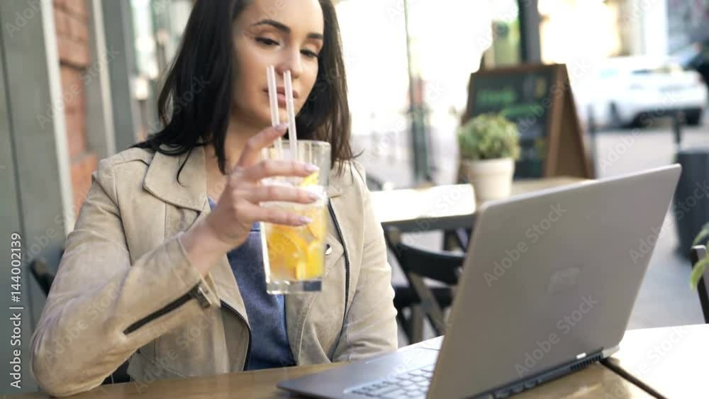 Happy woman watching movie on laptop and drinking cocktail in cafe in city
Happy woman watching movie on laptop and drinking cocktail in cafe in city