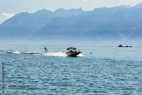 Motor boat and man wakeboarding on Lake Geneva in Lausanne