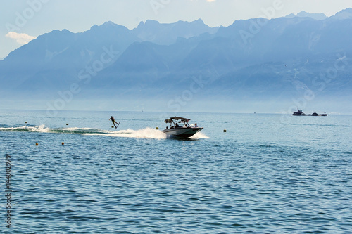 Motor boat and man wakeboarding on Lake Geneva in Lausanne photo