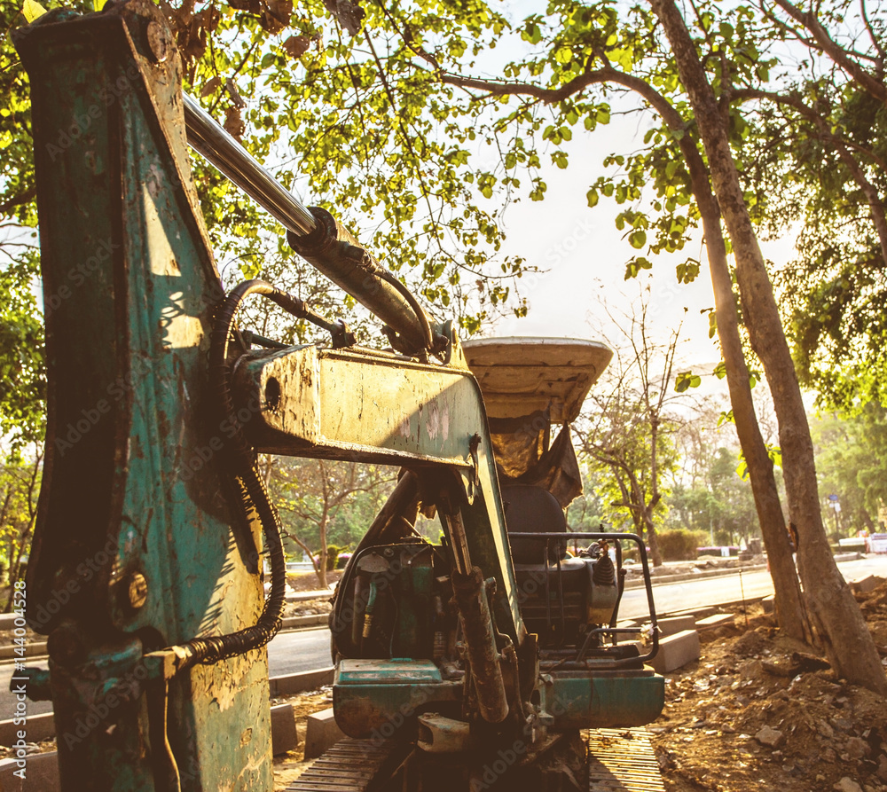 Excavator or backhoe at the construction site, sunset background, Track