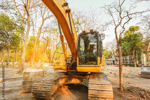 Excavator or backhoe at the construction site, sunset background, Track-type loader excavator machine doing earthmoving work at construction site 