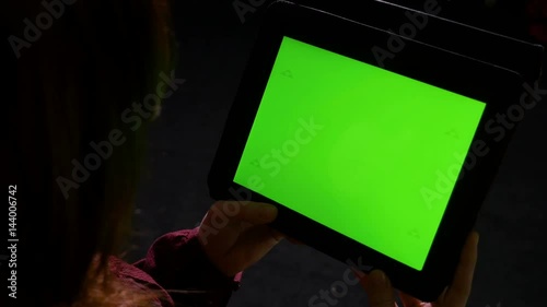 Young woman at using tablet pc late in the night and doing swipe gestures photo