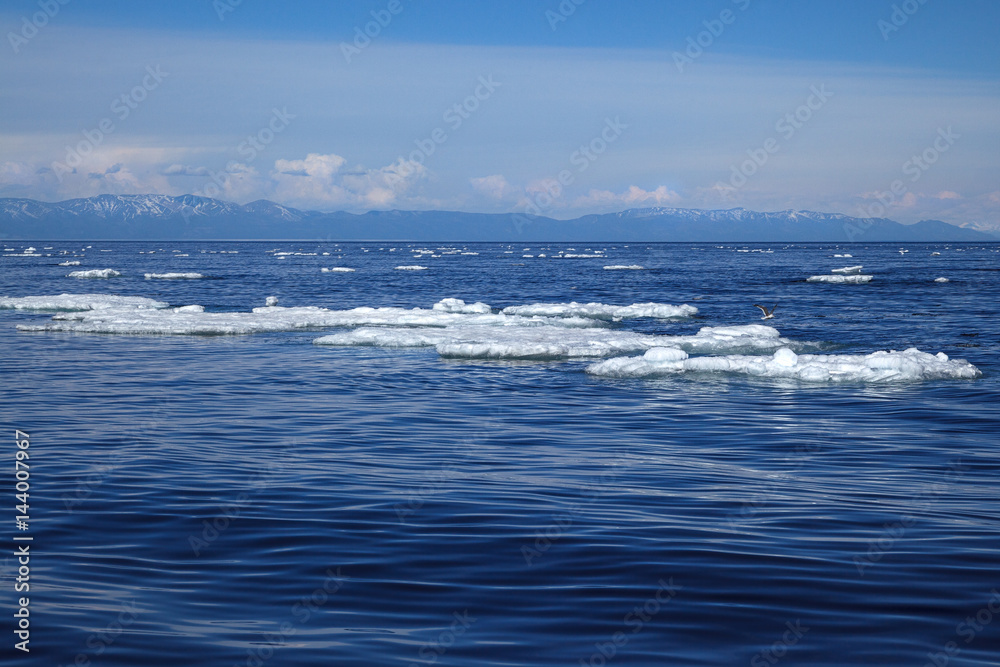 White ice floating on blue water surface