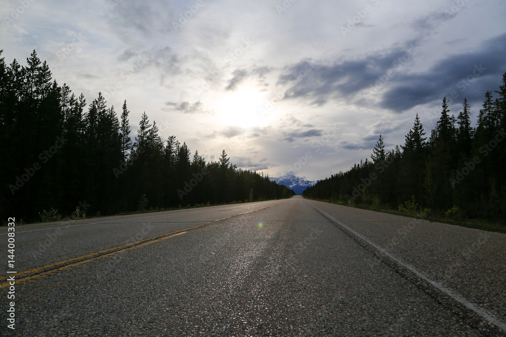 Road between mountains with clouds in the sky Road between mountains with clouds in the sky