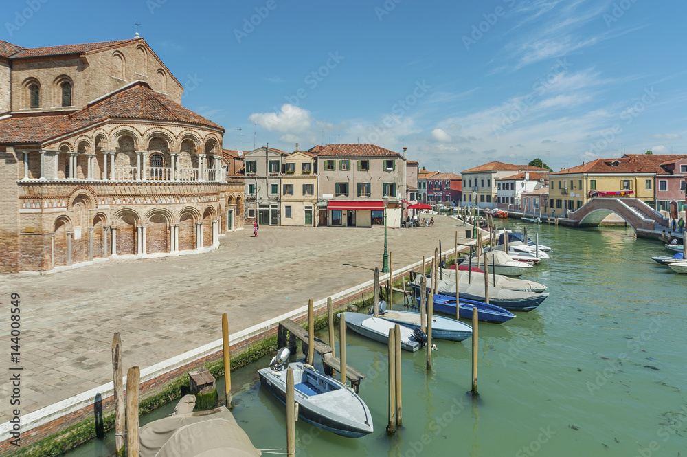 Murano island canal, colorful houses and boats, Venice, Italy.