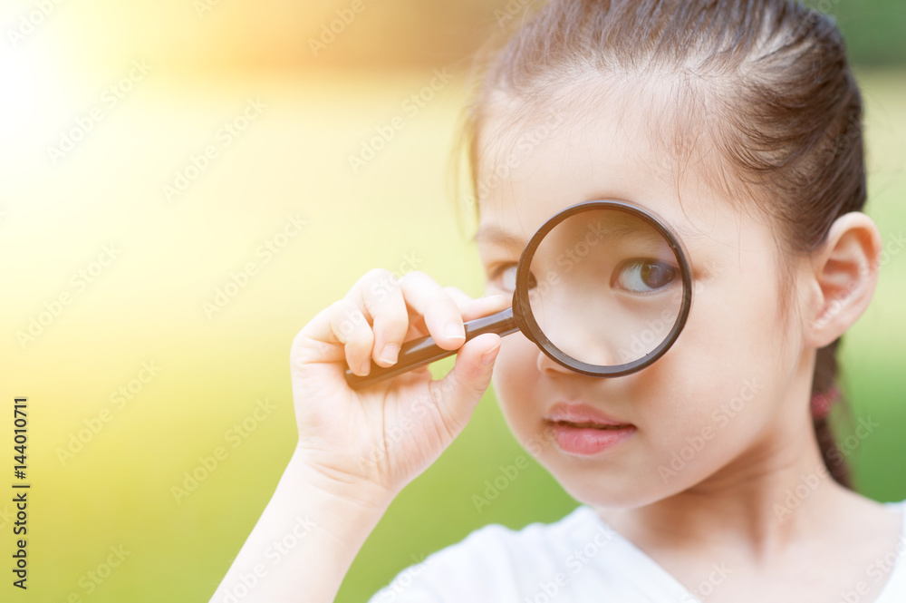 Asian child with magnifier glass at outdoors. Asian child with magnifier glass at outdoors.