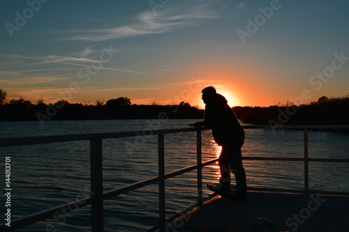 Fishing Red Sunset Fisherman standing on a dock in the sunset