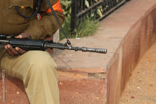 Sitting security man holding rifle at Delhi,India.