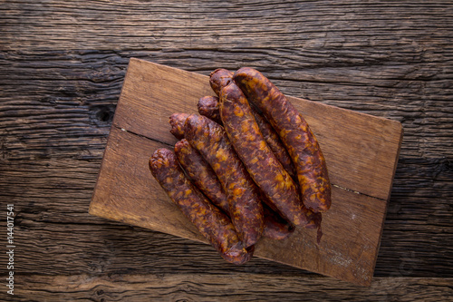 Sausages. Smoked Sausages. Chorizo sausages with vegetable rosemary spices and kitchen utensil.