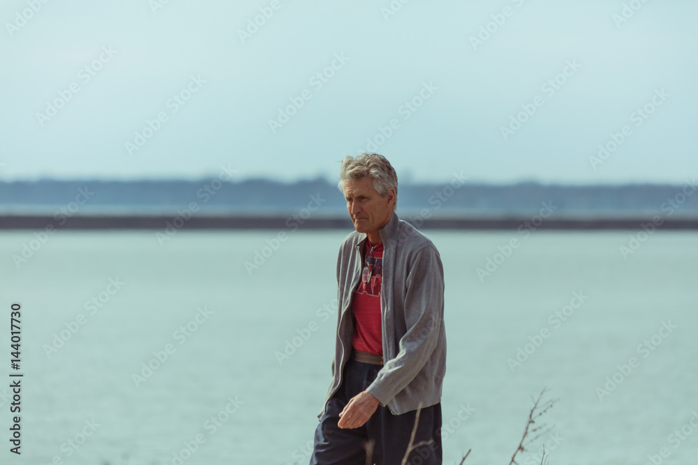 Older Man Walking Along Lake Older Man Walking Along Lake