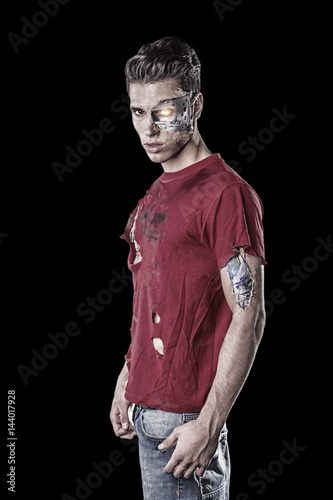 Attractive Young Man with Robotic Skin Art and Ripped T-Shirt Looking at the Camera, isolated on black Background. photo