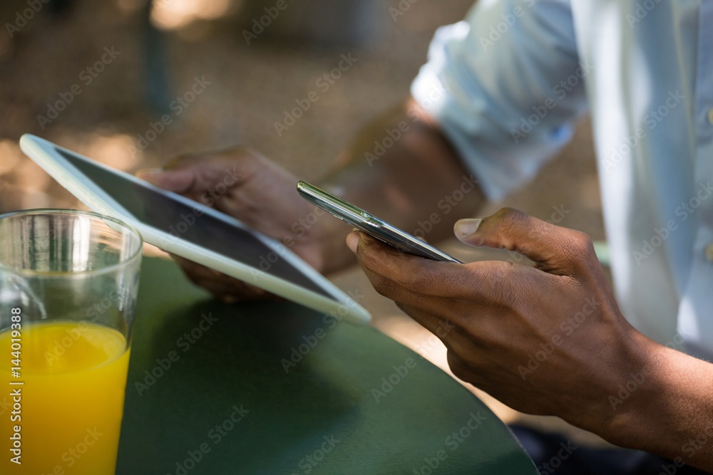 Man holding mobile phone and digital tablet at restaurant Man holding mobile phone and digital tablet at restaurant