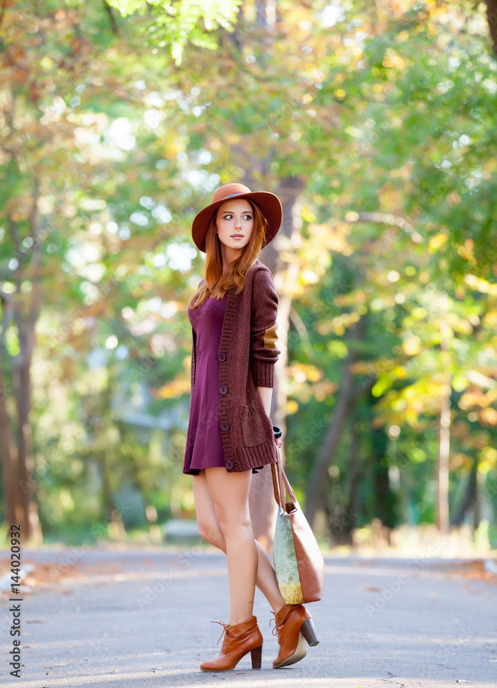 photo of beautiful young woman standing on the wonderful autumn park background