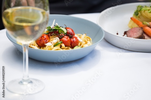 Lunch and wine glass on dining table at restaurant