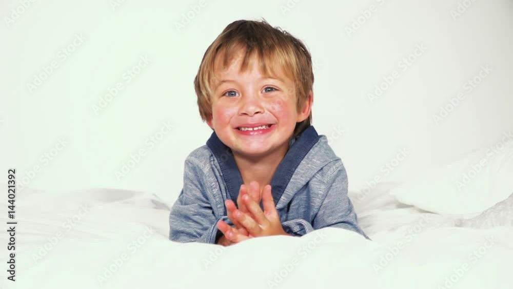 blonder bub liegt und spielt im bett blonder bub liegt und spielt im bett