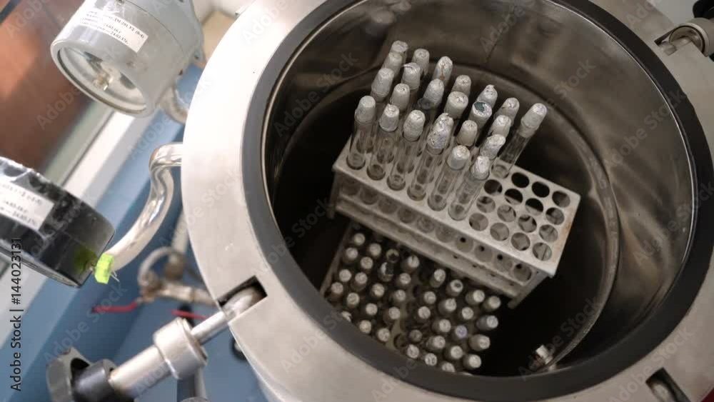 The lab assistant puts the rack with the test tubes into the autoclave ...