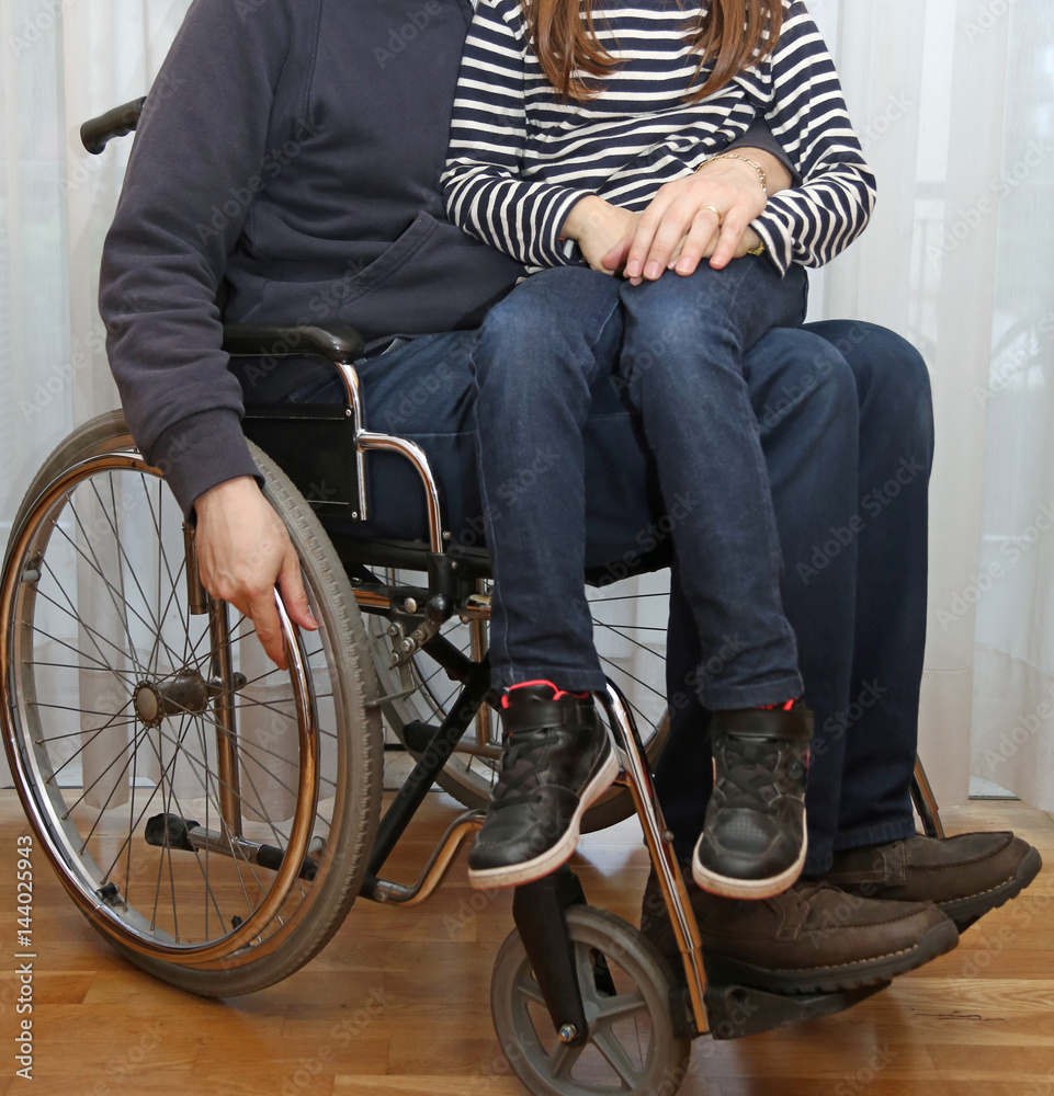 Obraz premium disabled parent in a wheelchair with his little daughter
