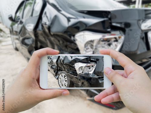 фотографія Car crash accident damaged with hand using smartphone taking photo