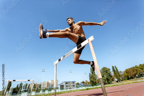 Professional athlete hurdling during the race