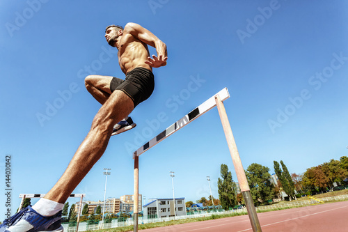 Professional athlete hurdling during the race