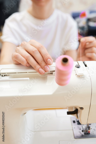 Tailor working on treading the sewing machine