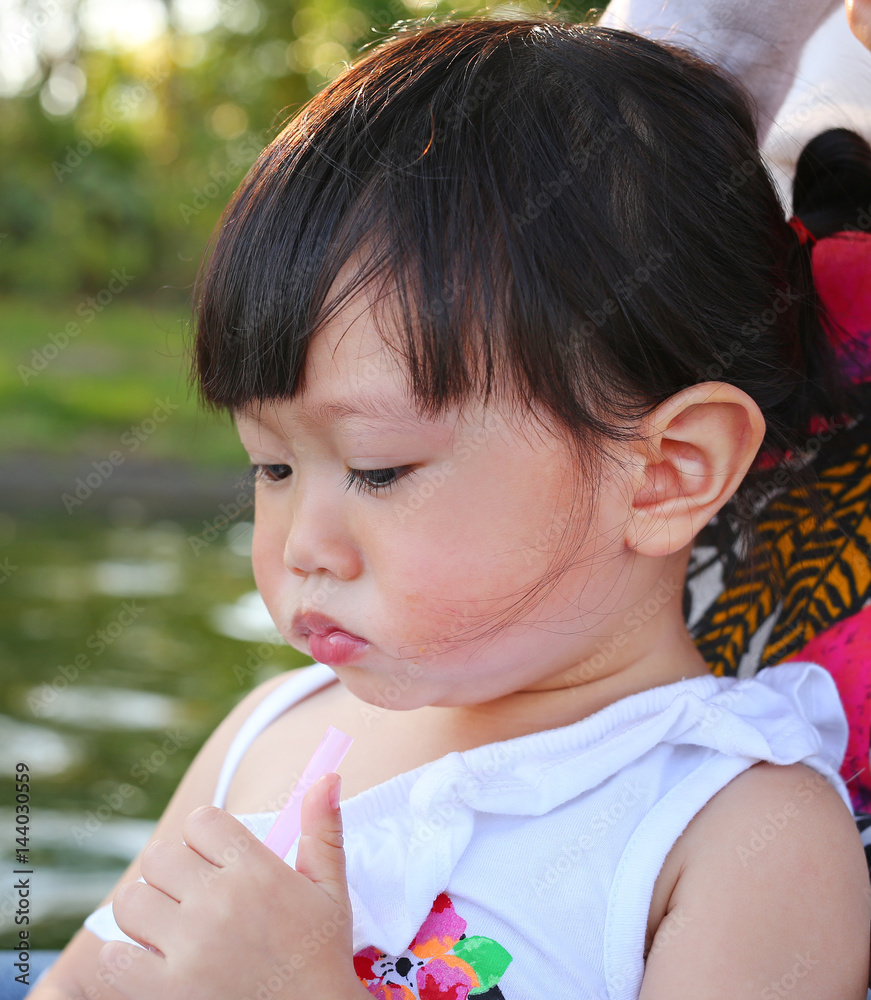 Portrait of one year old and six month child, Little asian girl in mother hug at the park Portrait of one year old and six month child, Little asian girl in mother hug at the park