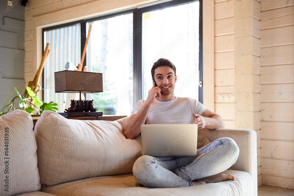 Man with phone and laptop at home Man with phone and laptop at home