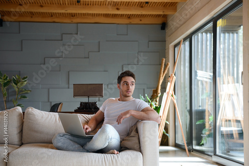 Young man looking away in living room photo