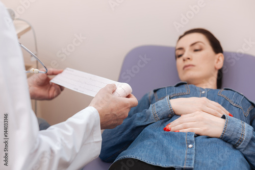 Commuted excellent specialist examining ladies electrocardiographic tracings photo