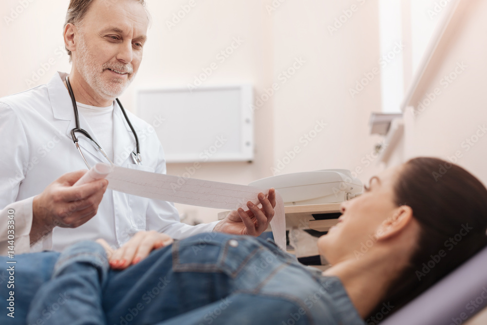 Optimistic cardiologist having some good news for young lady Optimistic cardiologist having some good news for young lady