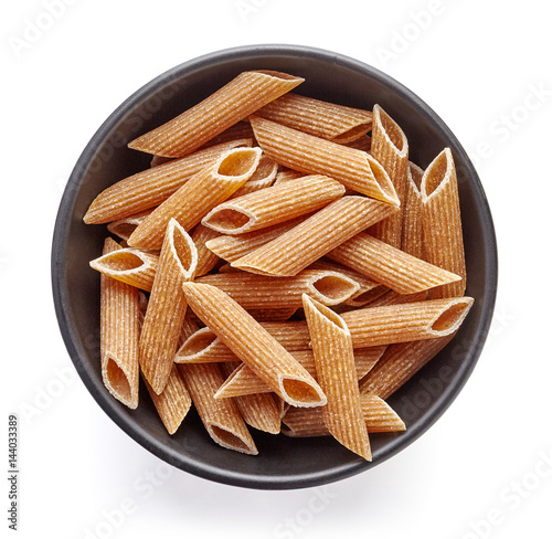 whole grain pasta in bowl isolated on white, from above