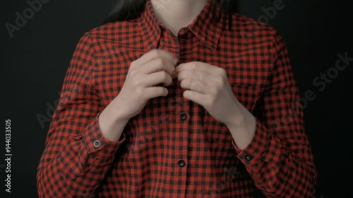 Woman unbuttoning shirt and showing bra