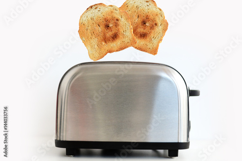 Roasted toast bread popping up of stainless steel toaster