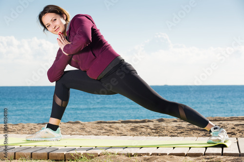 Positive girl exercising on exercise mat