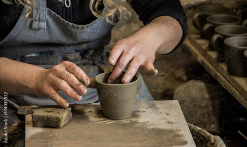 Woman potter at work creating some traditional cups of white clay, Margarites, Rethimno, Crete.