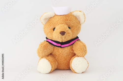 Teddy bear wearing a nurse hat on a white background.