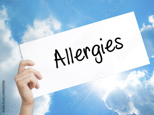 Allergies Sign on white paper. Man Hand Holding Paper with text. Isolated on sky background