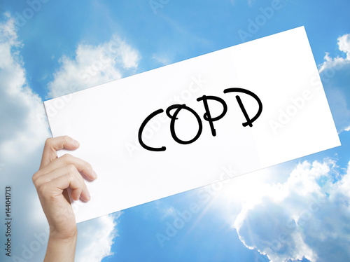 COPD Sign on white paper. Man Hand Holding Paper with text. Isolated on sky background photo
