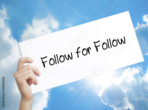 Follow for Follow Sign on white paper. Man Hand Holding Paper with text. Isolated on sky background photo