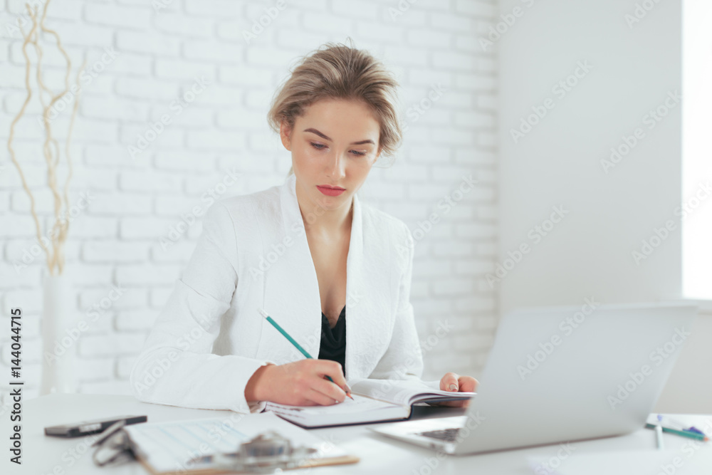 Portrait of beautiful young woman working in the office. Portrait of beautiful young woman working in the office.
