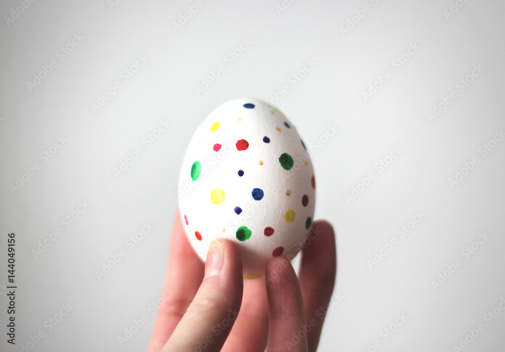 Easter egg in hand on white background.