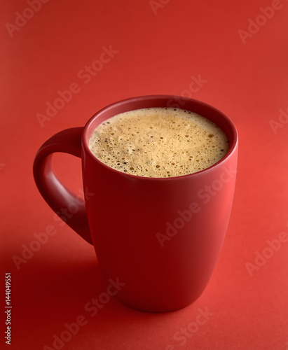 A red cup of tasty coffee  on a red background
