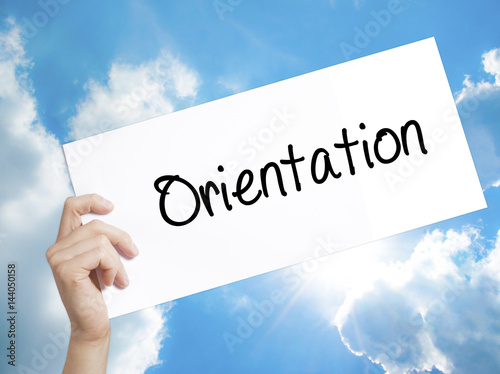 Orientation Sign on white paper. Man Hand Holding Paper with text. Isolated on sky background