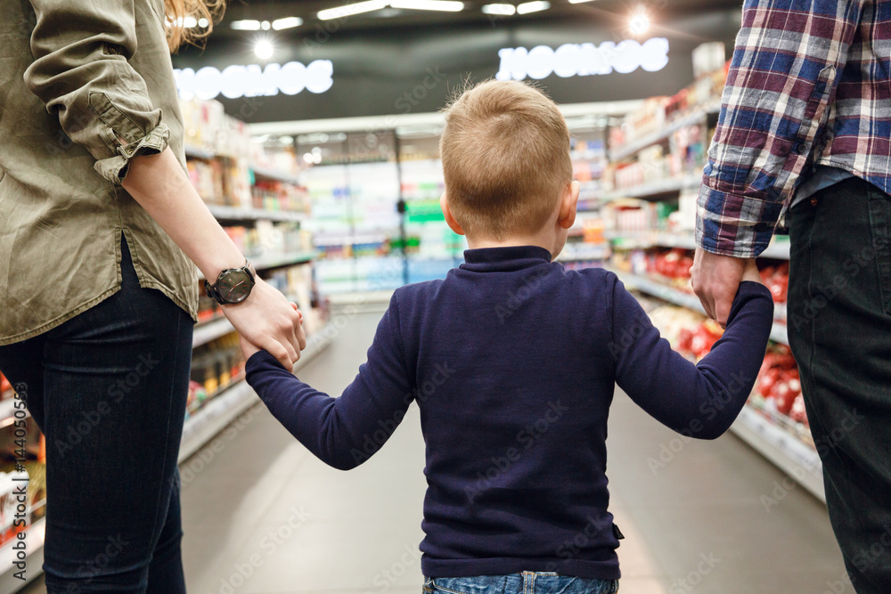 Obraz premium Back view of boy walking with parents